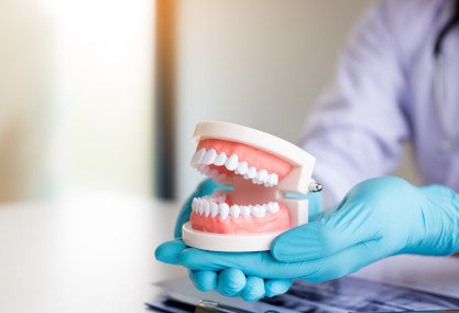 Dental implant and dental bridge parts set against a blue background