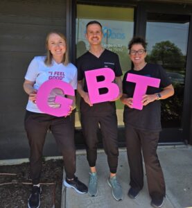 Dental team holding large cutouts of letters “GBT”